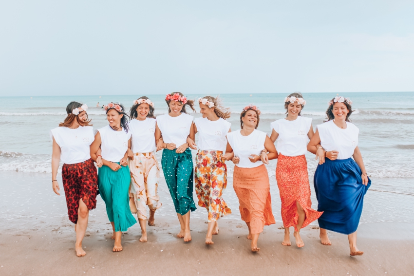 groupes de jeunes femmes en jupes longues qui marchent sur la plage